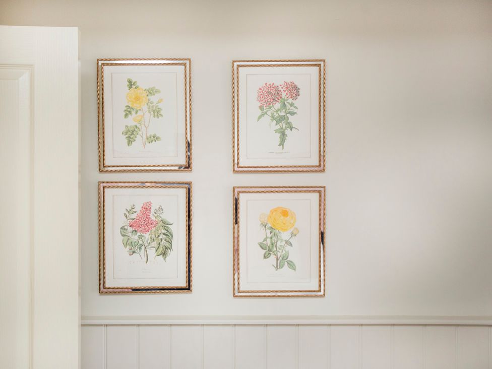 Four framed flower illustrations on a wall at Apartment 1, 86 Dyer Street in Cirencester