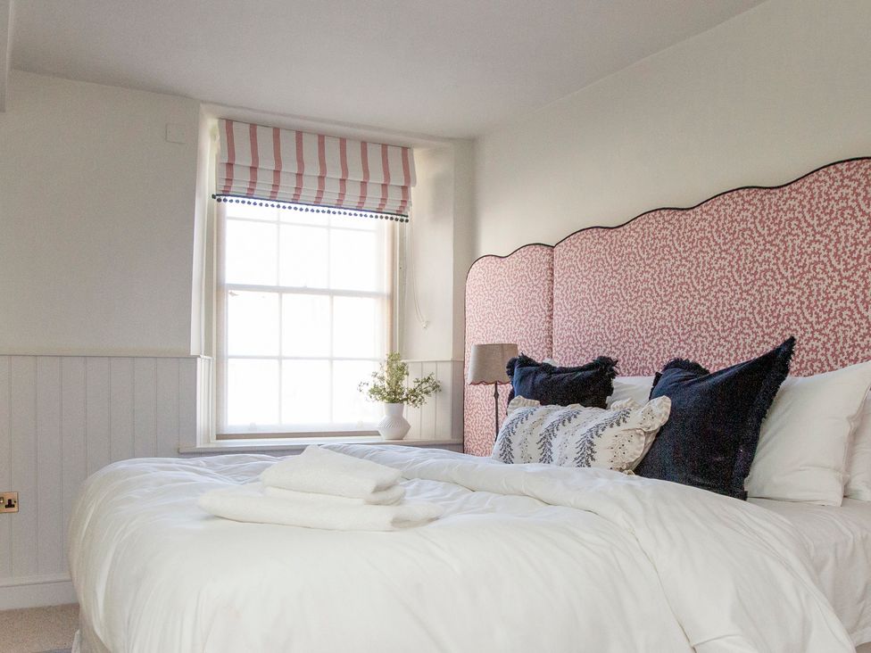 A bedroom with a bed and window at Apartment 1, 86 Dyer Street Cirencester