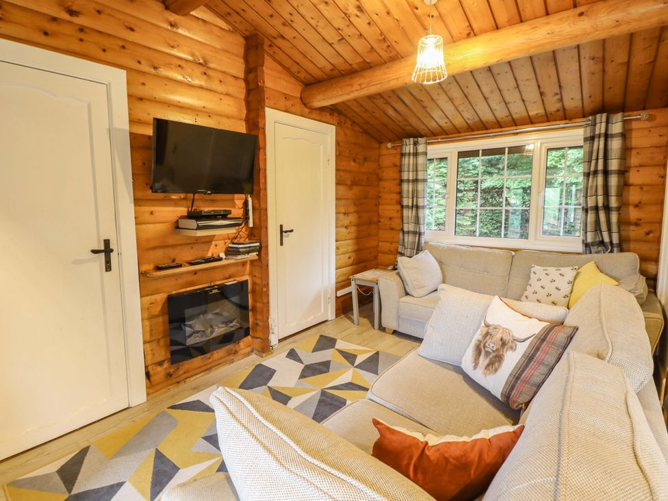 A living room with a sofa and television at Swn Yr Afon - No 333 