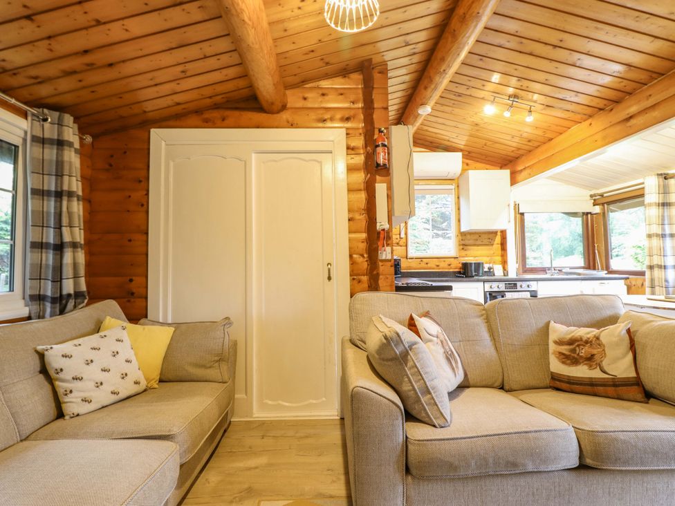 A living room with a sofa and cupboard at Swn Yr Afon - No 333