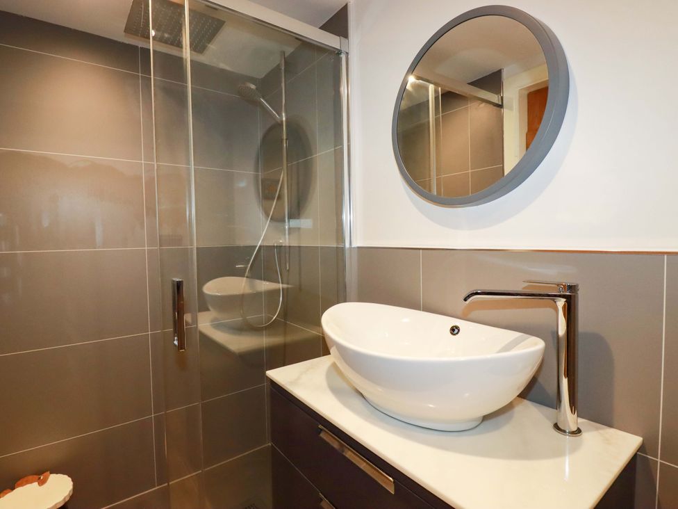 A bathroom with a shower and sink at Heatherlea Cottage in St. Austell