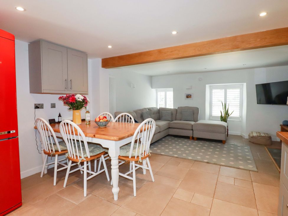 A kitchen with a dining area and a sofa at Heatherlea Cottage in St. Austell