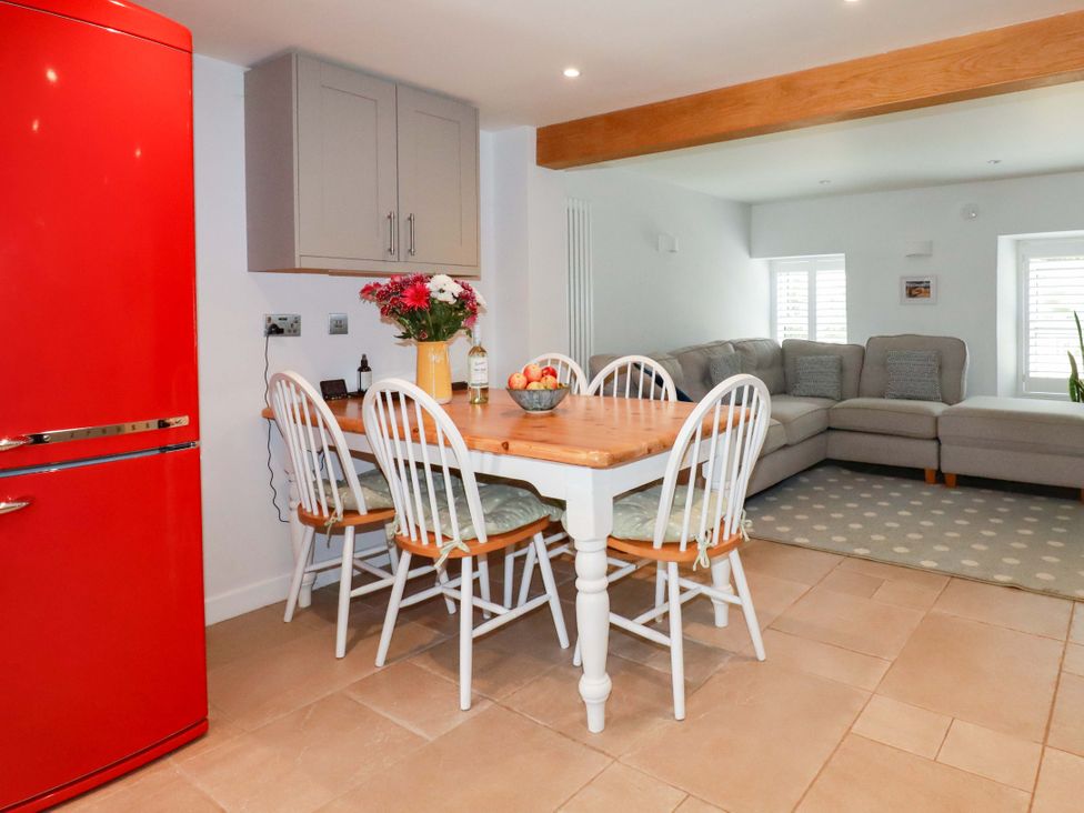 A kitchen with a dining table and chairs at Heatherlea Cottage in St. Austell