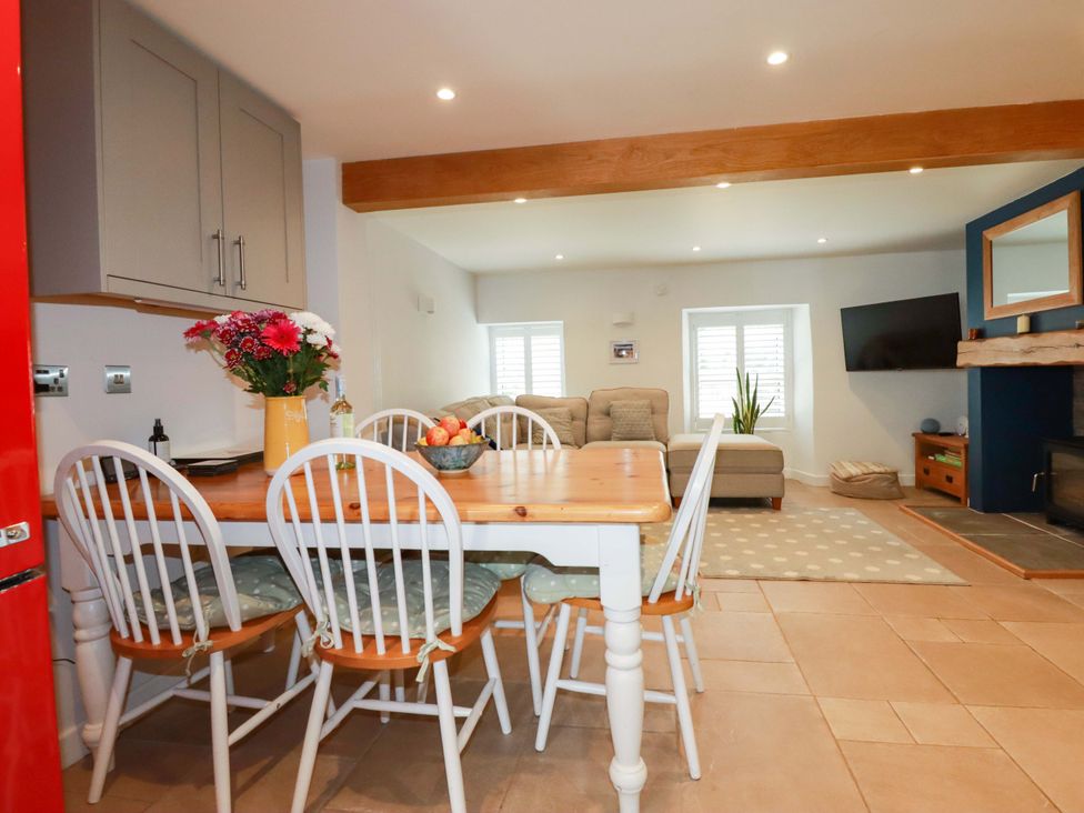 A living room with a dining area and couch at Heatherlea Cottage in St. Austell
