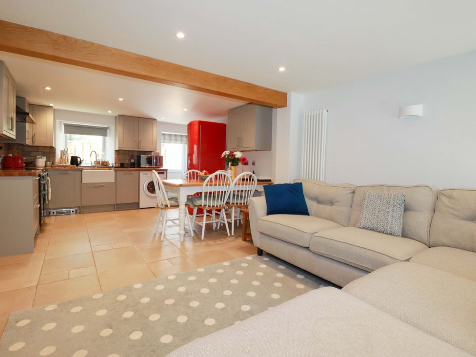 A kitchen with dining area and appliances at Heatherlea Cottage in St. Austell
