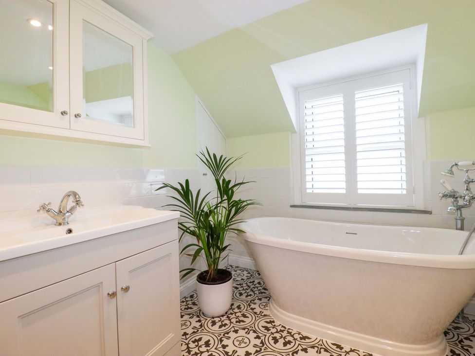 A bathroom with a bathtub and sink at Heatherlea Cottage in St. Austell