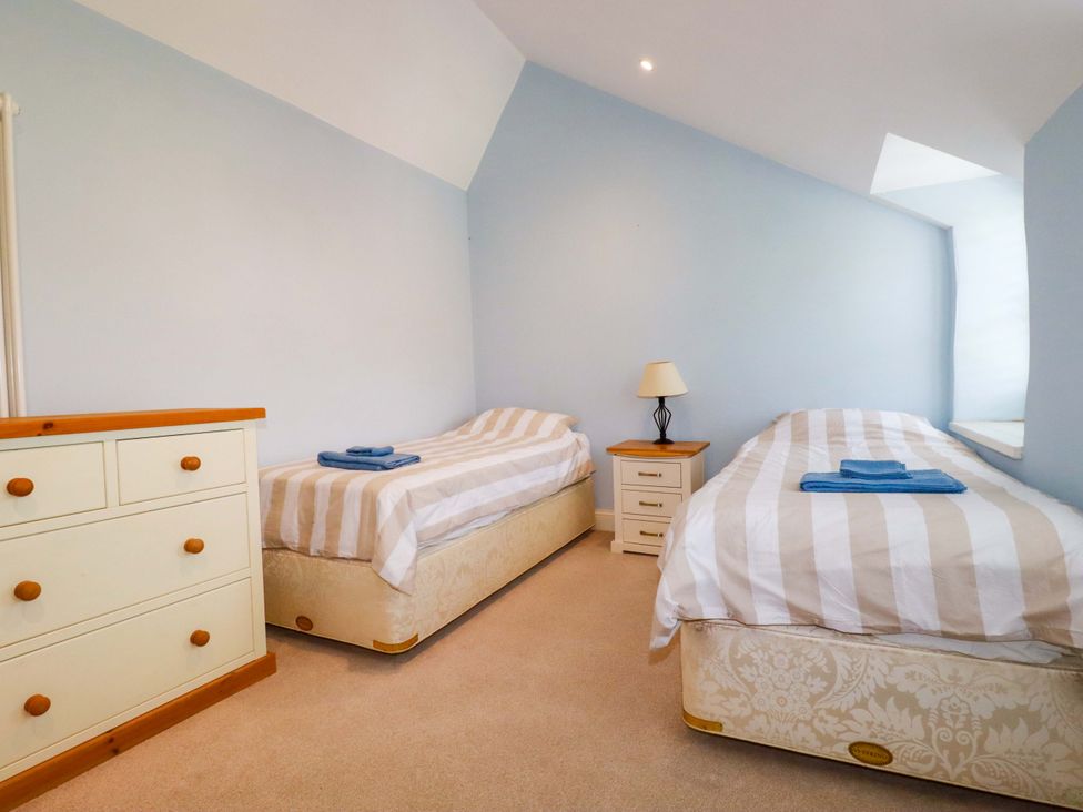 A bedroom with two single beds and a dresser at Heatherlea Cottage in St. Austell