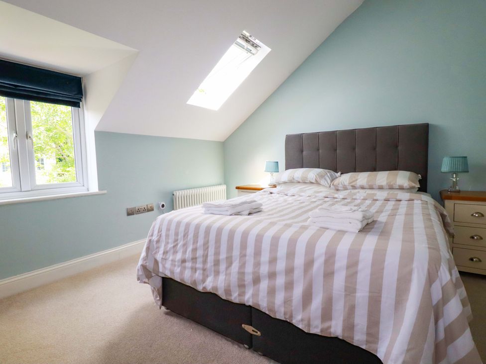 A bedroom with a bed and window at Heatherlea Cottage St. Austell