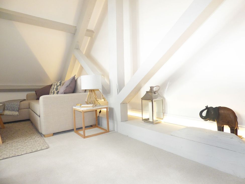 A living room with a sofa, table, lamp and decorative items at 1 Chapel Place in Chester