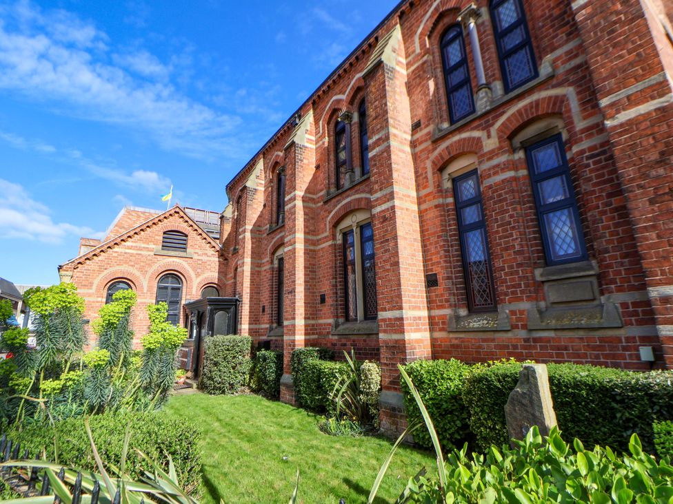 A brick building with windows and a garden at 1 Chapel Place Chester