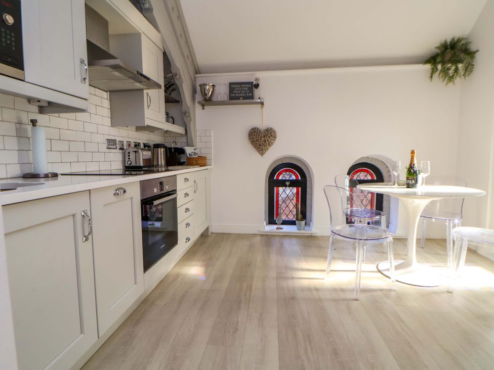 A kitchen with appliances and a table with chairs at 1 Chapel Place Chester