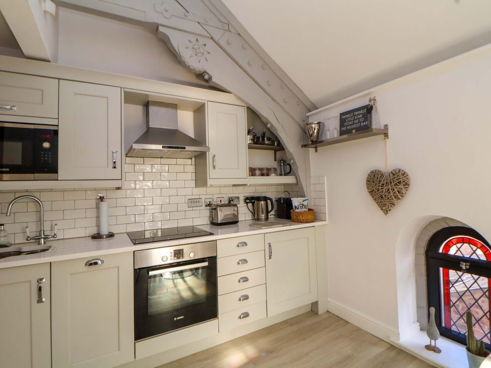 A kitchen with appliances and shelves at 1 Chapel Place Chester