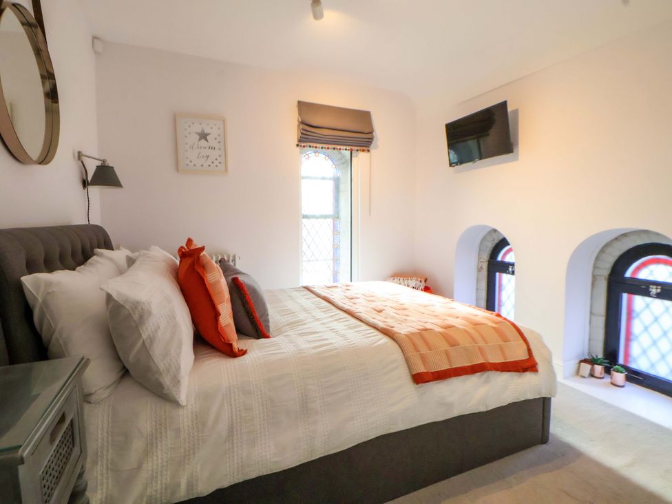 A bedroom with a bed and windows at 1 Chapel Place Chester