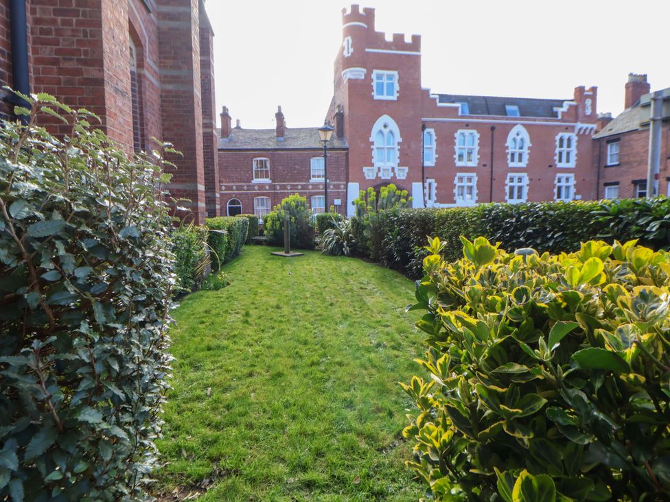 A garden area with grass and hedges at 1 Chapel Place Chester