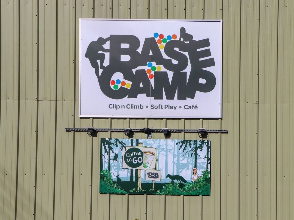 A sign for Base Camp featuring climbing and café details