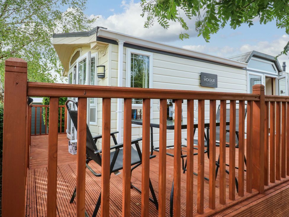 An outdoor patio with decking and chairs at Plot 12 in Carlisle