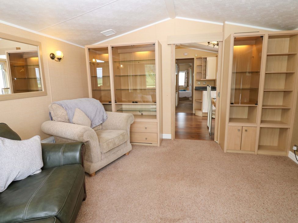 A living room with a sofa and shelving units at Plot 12 in Carlisle