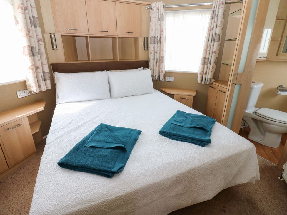 A bedroom with a bed and towels at Plot 12 in Carlisle