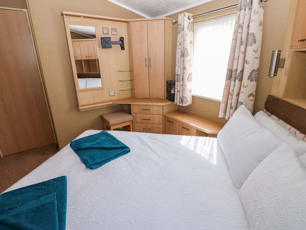 A bedroom with a bed and dressing table at Plot 12 in Carlisle