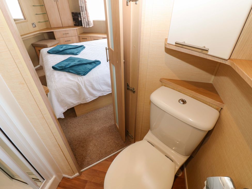 A bathroom with a toilet next to a bedroom at Plot 12 in Carlisle