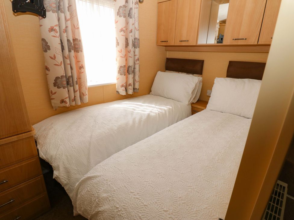 A bedroom with two single beds and a window at Plot 12 in Carlisle