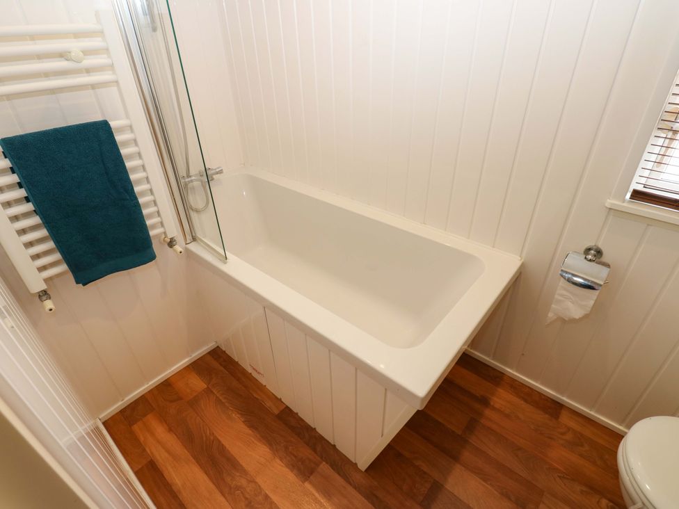 A bathroom with a bathtub and towel rack at Plot 12 in Carlisle