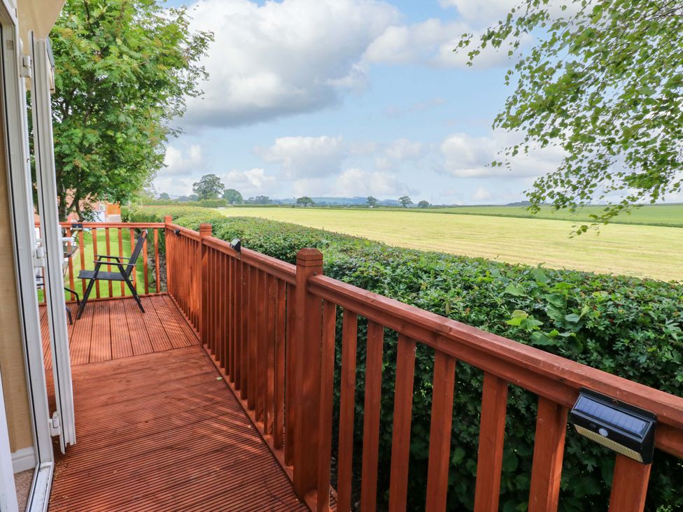 A balcony with a chair overlooking a field at Plot 12 in Carlisle