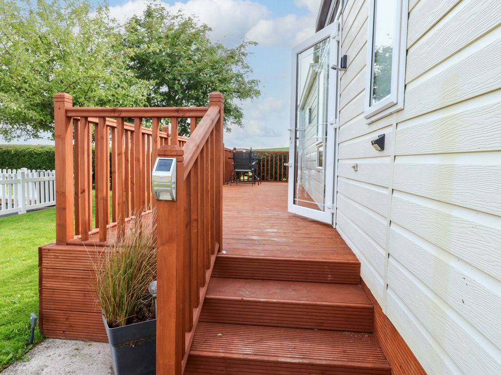 A deck area with stairs leading to a door at Plot 12 Carlisle