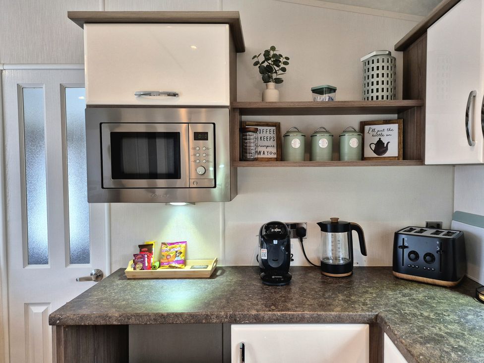 A kitchen with microwave, coffee maker, kettle and toast at Fernwood Lodge in Fritton near Belton, Norfolk