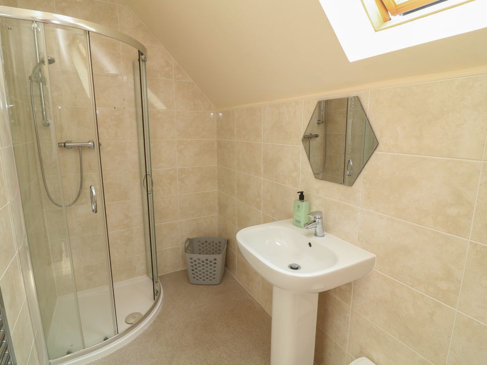 A bathroom with a shower, sink, and a waste bin at Lodge 7 in Brigg
