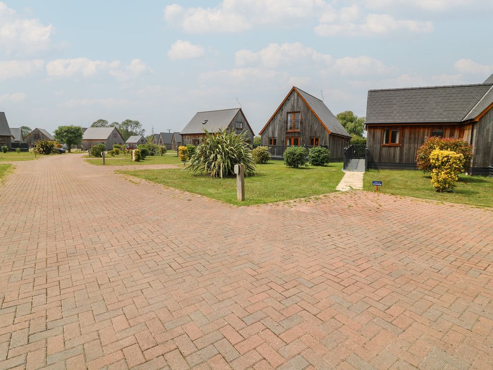 An outdoor area with holiday cabins and a paved driveway at Lodge 7 in Brigg