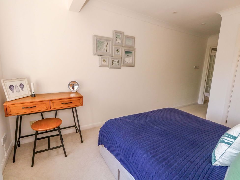 A bedroom with a bed and a desk at Apartment 11 in Poole
