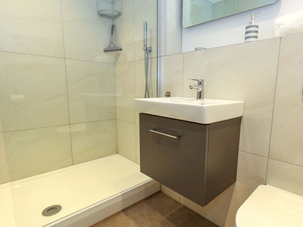 A bathroom with a shower, sink, and toilet at Apartment 11 in Poole