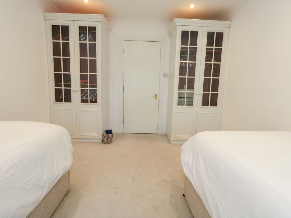 A bedroom with two beds and wardrobes at Apartment 11 in Poole