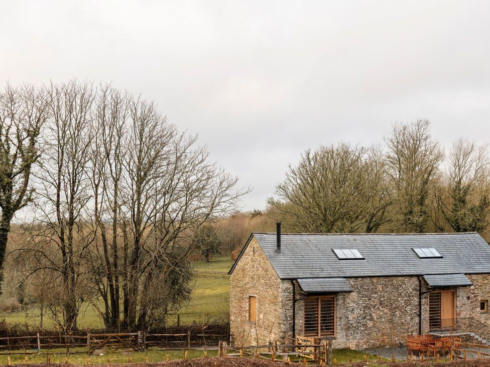 A house with trees and a fence at Lower Walreddon Farm in Tavistock
