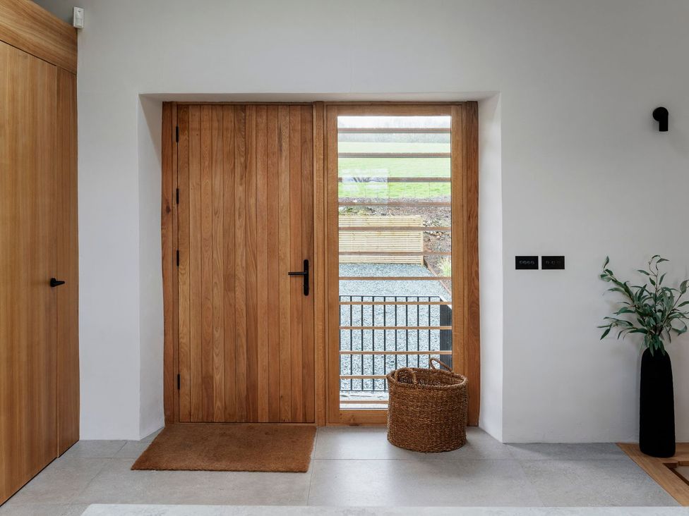 An entrance hallway with a wooden door and basket at Lower Walreddon Farm Tavistock