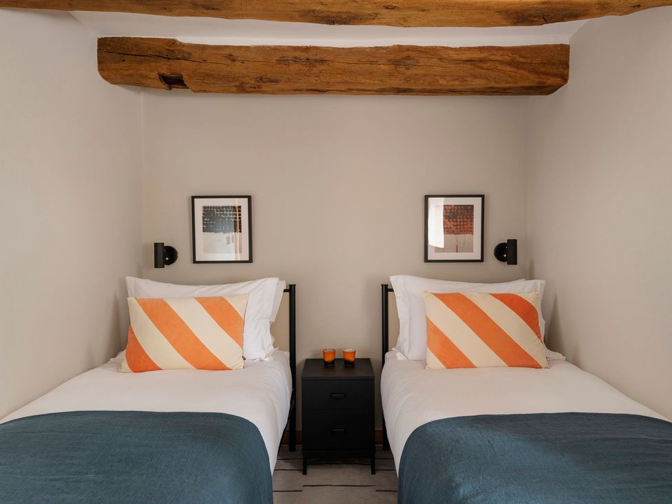 A bedroom with two beds and a nightstand at Lower Walreddon Farm Tavistock