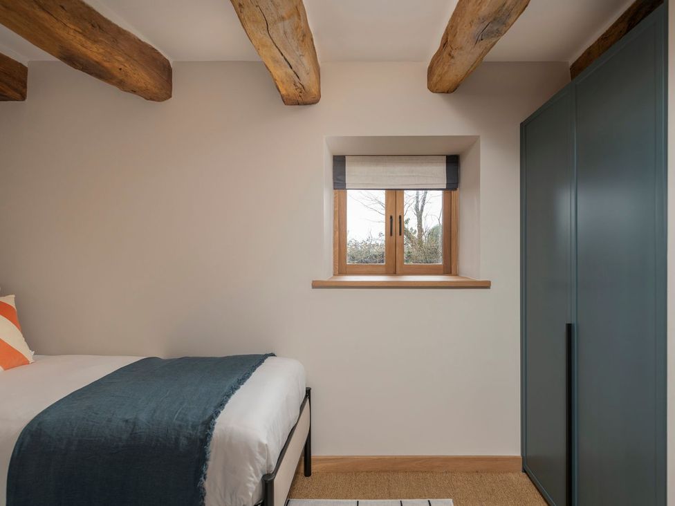 A bedroom with a bed and window at Lower Walreddon Farm Tavistock