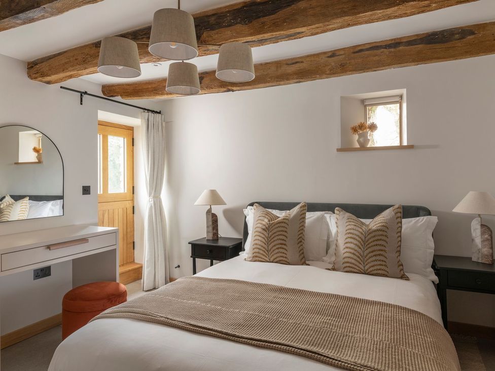 A bedroom with a bed and dresser at Lower Walreddon Farm in Tavistock