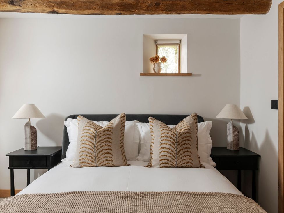 A bedroom with a bed and pillows at Lower Walreddon Farm in Tavistock