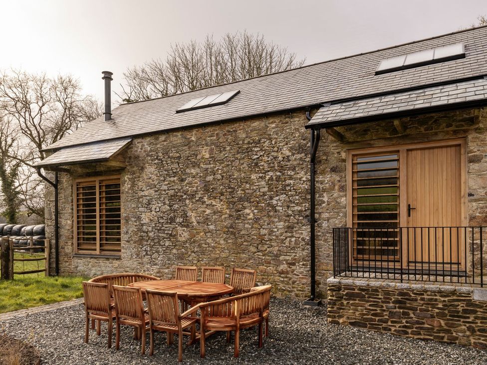 An outdoor patio with a table and chairs at Lower Walreddon Farm Tavistock