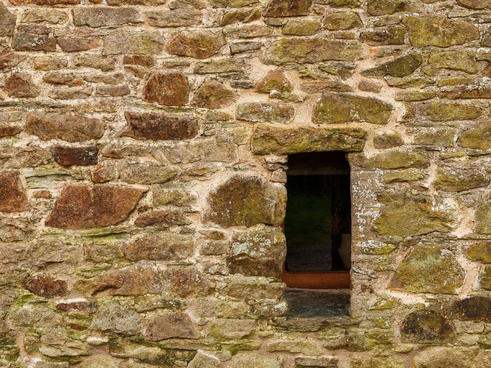 A stone wall with a window opening at Lower Walreddon Farm, Tavistock