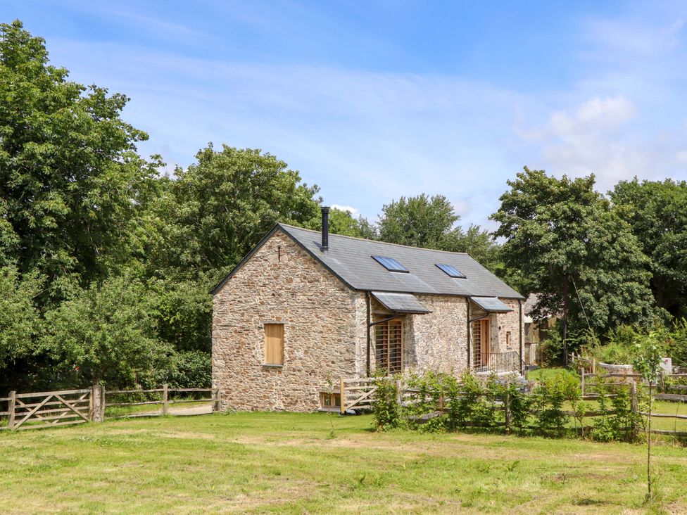A stone house with a grassy area at Lower Walreddon Barn Tavistock