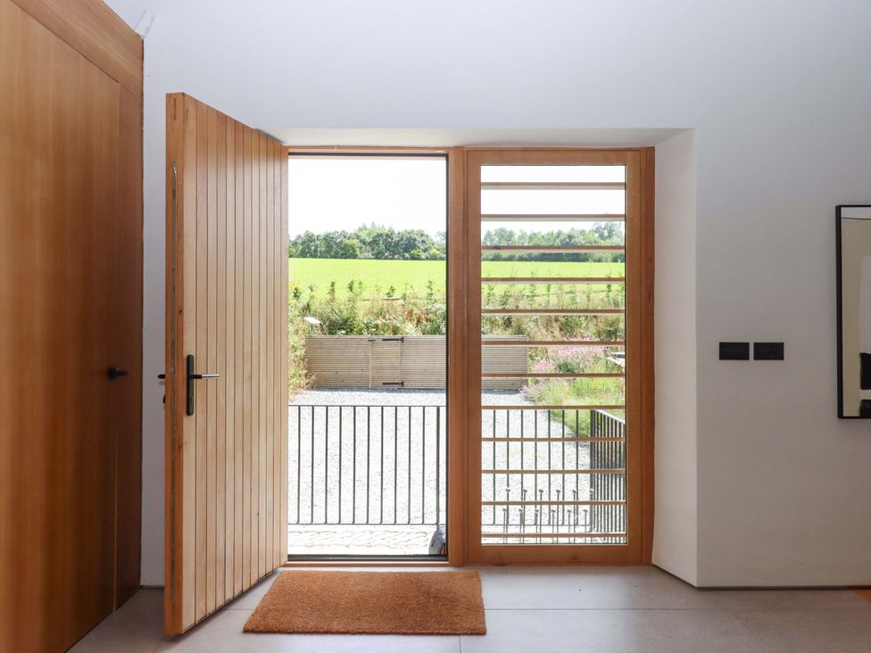 An entrance with a wooden front door and view of the outdoors at Lower Walreddon Barn Tavistock