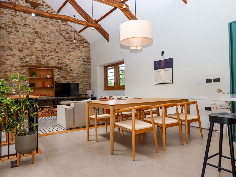 A dining room with table and chairs at Lower Walreddon Barn in Tavistock