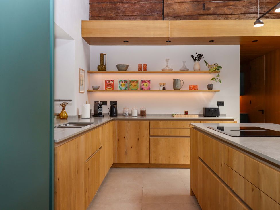 A kitchen with wooden cabinets and countertop at Lower Walreddon Barn Tavistock