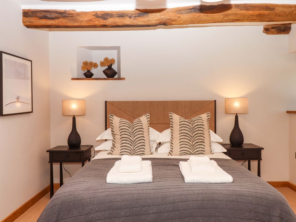 A bedroom with a bed and bedside table at Lower Walreddon Barn in Tavistock