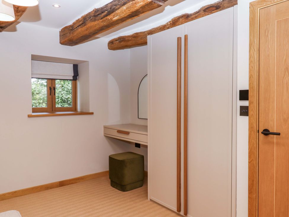 A bedroom with a window and wardrobe at Lower Walreddon Barn Tavistock