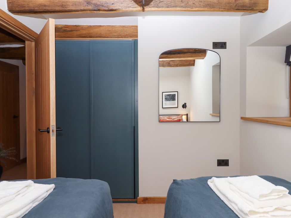 A bedroom with a mirror and bed at Lower Walreddon Barn Tavistock