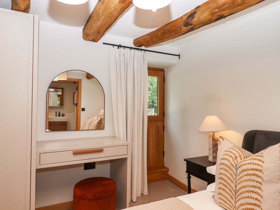 A bedroom with a mirror and desk at Lower Walreddon Barn Tavistock